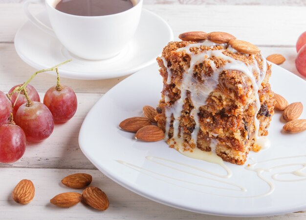 Torta com caramelo, molho de leite branco e amêndoas em um prato branco