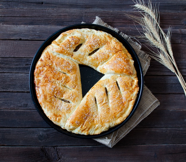 Torta com gergelim em uma demissão, espigas de trigo, vista superior