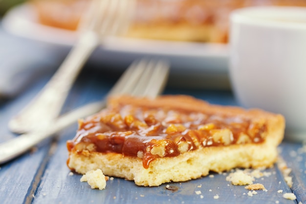 Foto torta com nozes e caramelo e café no azul