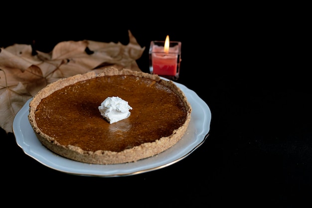 Torta de abóbora caseira, com creme e porção quebrada sobre fundo claro, sobremesa de ação de graças