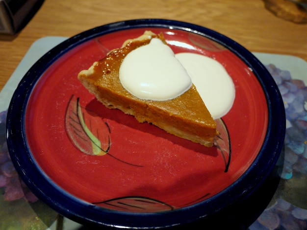 Foto torta de abóbora com creme num prato vermelho