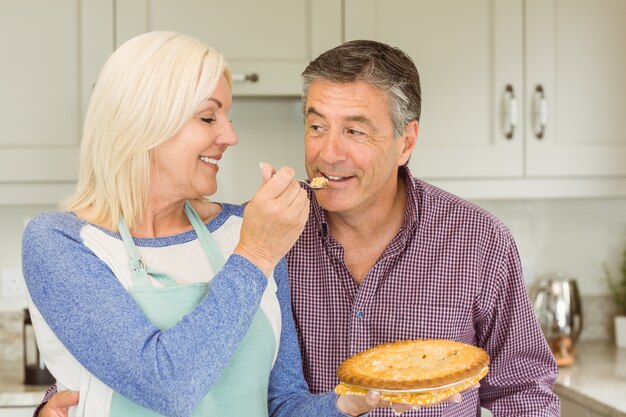 Torta de alimentação loura madura feliz para o marido