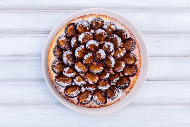 Torta de ameixa caseira na superfície de madeira