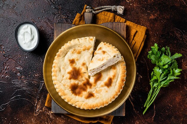 Torta de carne Kubdari Pão plano georgiano saboroso Recheado com carne Fundo escuro Vista superior