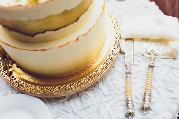 Foto torta de casamento branca de três camadas decorada com flores de máscara em uma mesa de madeira branca imagem para um menu ou um catálogo de doces com espaço para cópia