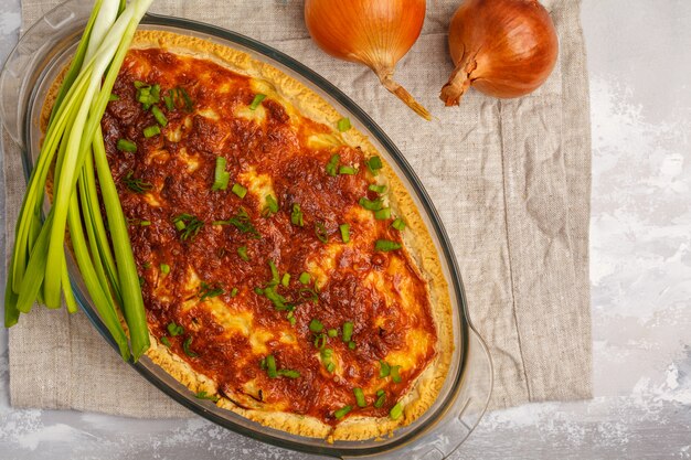 Torta de cebola francesa tradicional. Quiche Lorraine com cebola, queijo e ovos em um prato de forno de vidro, vista superior