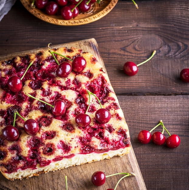 Torta de cereja assada em uma placa de madeira marrom