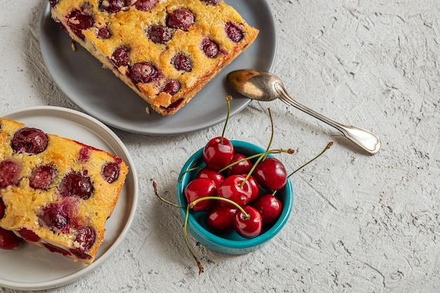 Torta de cereja Clafoutis torta tradicional francesa em pratos na vista superior da mesa cinzenta com espaço de cópia