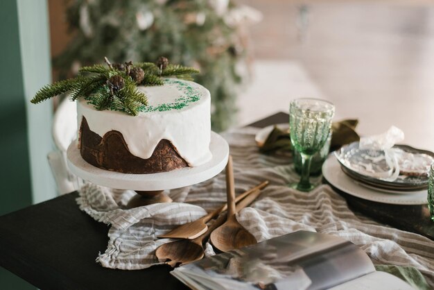 Foto torta de chocolate com glasura branca decorada com galhos de abeto para o natal ou ano novo no servido