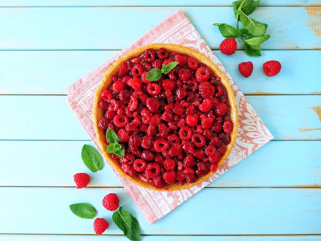 Torta de framboesa fresca com folhas de hortelã na mesa de madeira azul Fundo de verão