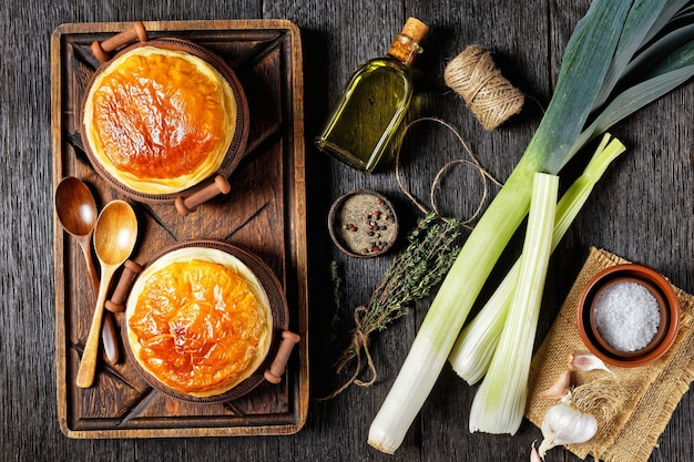 Torta de frango em potes rústicos de barro em uma placa de madeira rústica com especiarias e ervas, planta plana, vista horizontal de cima, culinária inglesa