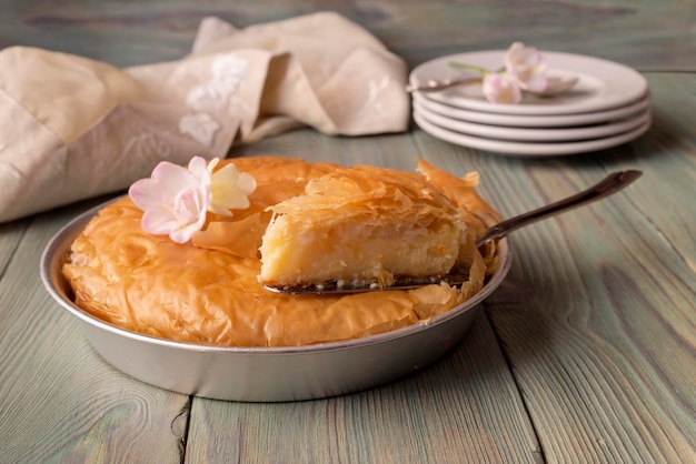 Torta de leite com molho em uma mesa de madeira cozinha grega