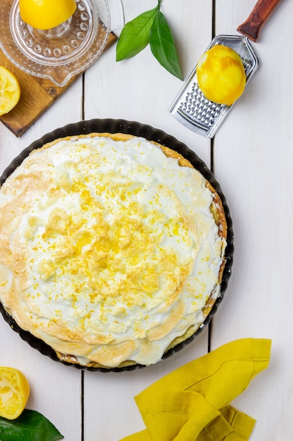 Torta de limão com merengue em um fundo de madeira.