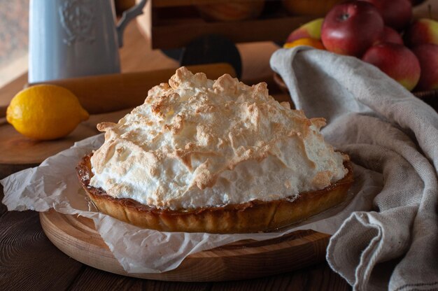 Torta de limão suculenta com merengue fofo em um fundo de madeira Fechar