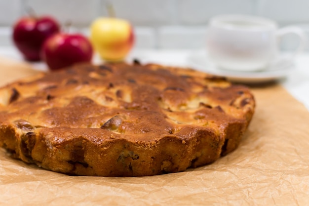 Torta de maçã assada caseira em um prato sobre uma mesa de madeira branca pronta para comer Lugar para uma inscrição