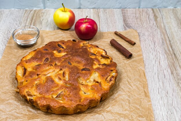 Torta de maçã assada caseira em um prato sobre uma mesa de madeira pronta para comer Lugar para uma inscrição