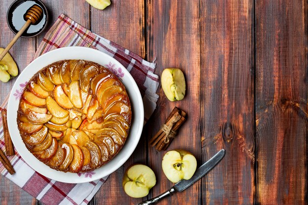 Torta de maçã caseira com caramelo e canela na mesa de madeira