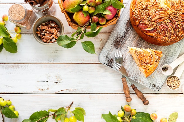 Torta de maçã caseira e ingredientes em um fundo de madeira branca Vista superior Espaço de cópia