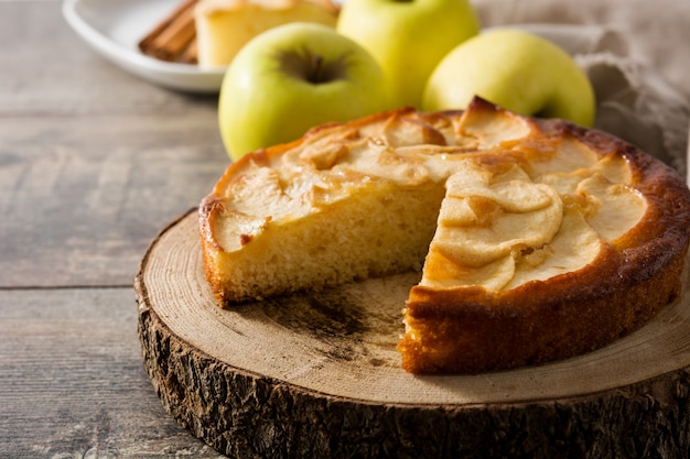 Torta de maçã caseira fatia na mesa de madeira.