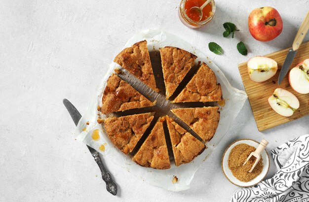 Torta de maçã deliciosa recém-assada cortada em pedaços servidos na mesa de luz branca espaço para texto