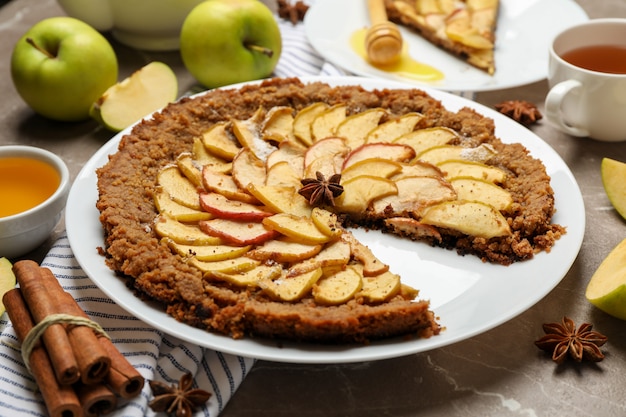 torta de maçã e ingredientes em fundo cinza