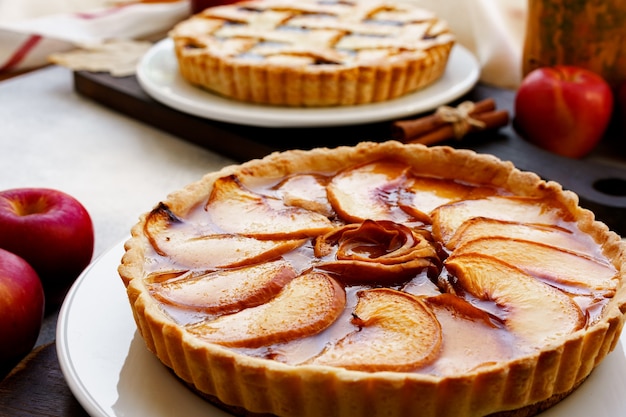 Torta de maçã e maçãs vermelhas na mesa de madeira