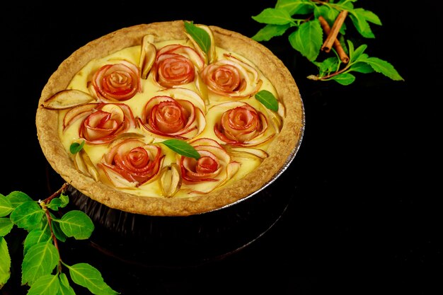 Torta de maçã em formato de rosa com paus de canela