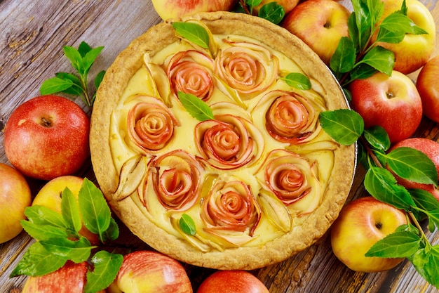 Torta de maçã fresca com decoração como uma rosa na mesa de madeira. Vista do topo.