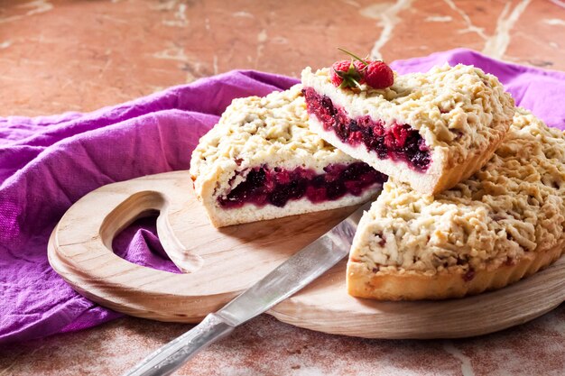 Torta de massa quebrada caseira berry com crumble na placa de madeira