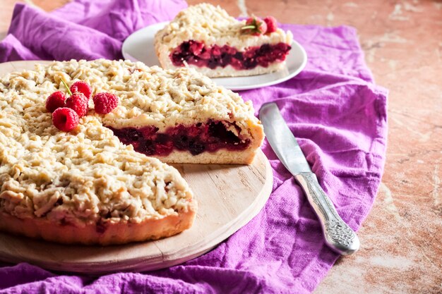 Torta de massa quebrada caseira berry com crumble na placa de madeira