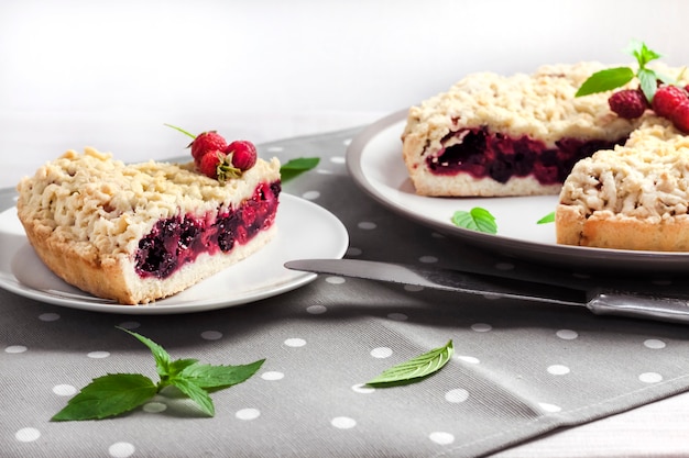 Torta de massa quebrada caseira berry com crumble no prato e pano pontilhado cinza