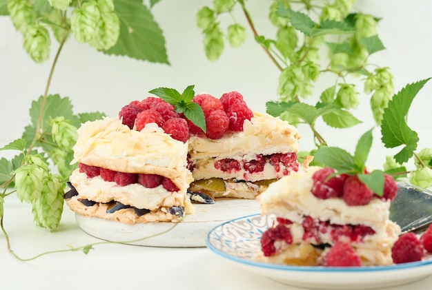 Torta de merengue redonda com framboesas frescas em uma sobremesa de pavlova de fundo branco