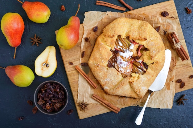 Torta de pêra caramelizada com canela e passas em um fundo preto