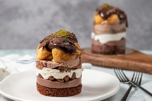 Torta de profiteroles em camadas de creme batido, chocolate e torta de pistache