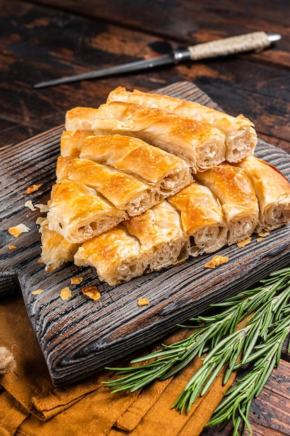 Torta de spanakopita grega caseira com queijo orgânico na placa de madeira Fundo de madeira Vista superior