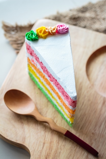 Foto torta deliciosa del arco iris en la placa de madera