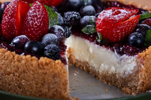 Foto torta doce com bagas com uma fatia cortada