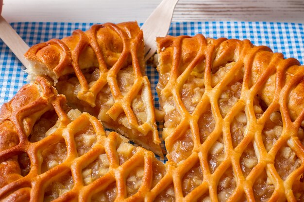 Torta fatiada e um garfo. Talheres com pedaço de torta. Produto fresco assado no café. Pastelaria com maças e canela.