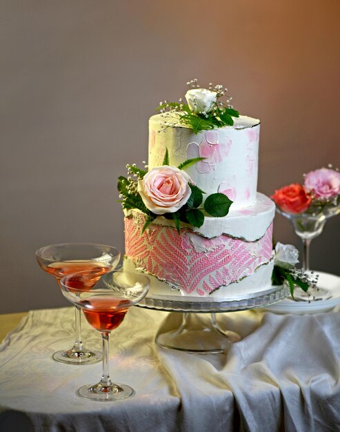 Torta festiva de boda decorada con flores frescas en un fondo oscuro