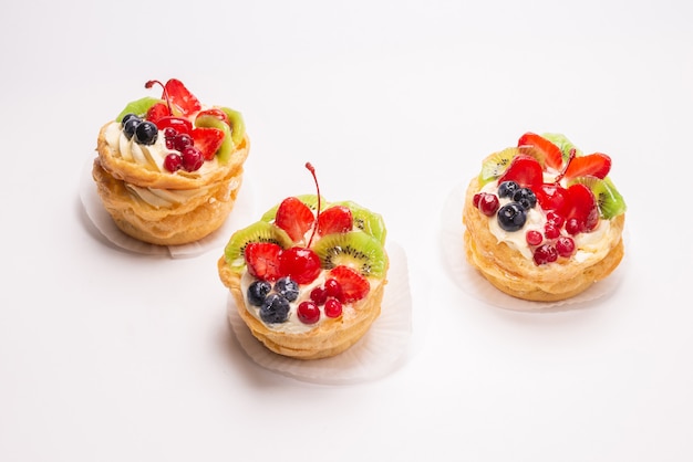 Torta hecha en casa con crema y frutas aisladas en blanco.