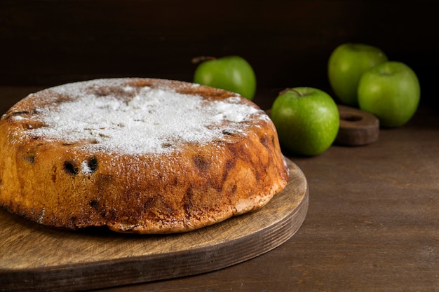 Foto torta hecha en casa con las manzanas en fondo oscuro.