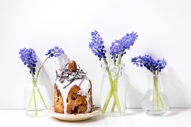 Torta kulich de Pascua tradicional casera con nidos de chocolate y huevos en platos de cerámica decorados con flores de muscari en una mesa de mármol blanco Tradicional ortodoxo Pascua Ruso Ucraniano hornear