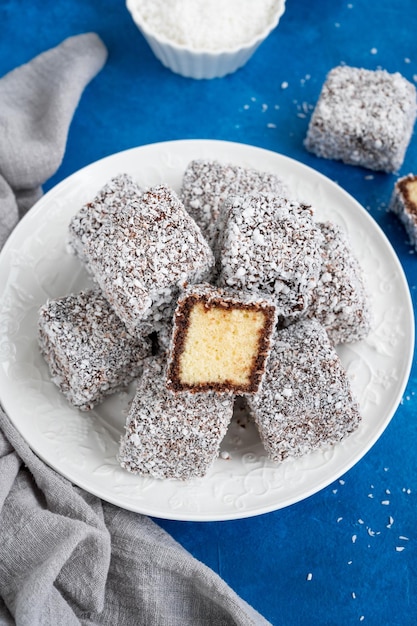 Torta Lamington australiana con glaseado de chocolate y copos de coco con una taza de té Enfoque selectivo