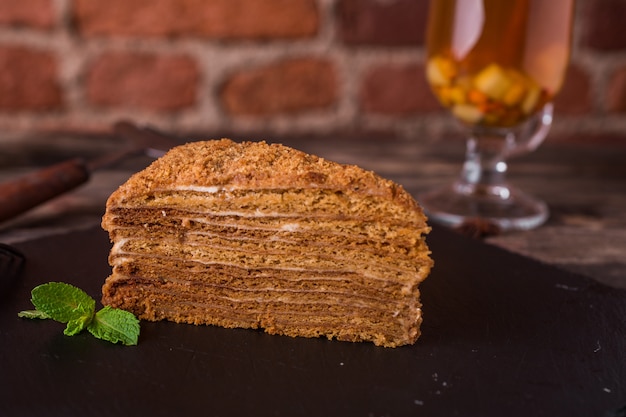 Foto torta de miel con menta en un plato de piedra en la mesa de madera rústica