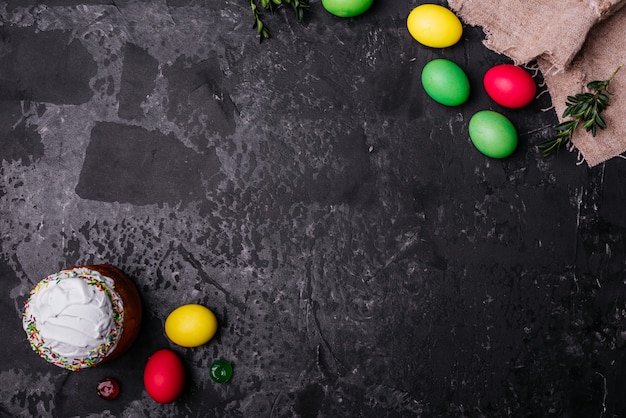 Torta de Pascua y huevos coloridos en un fondo oscuro