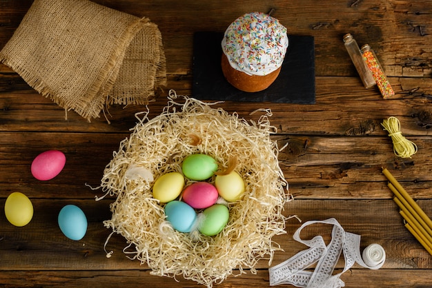 Torta de Pascua y huevos coloridos en una tabla de madera.