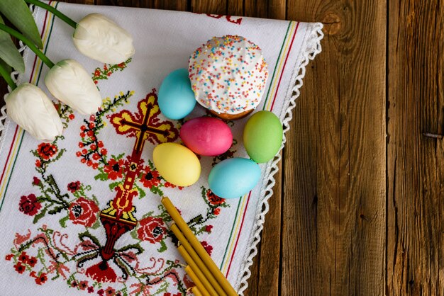 Torta de Pascua y huevos coloridos en una tabla de madera.