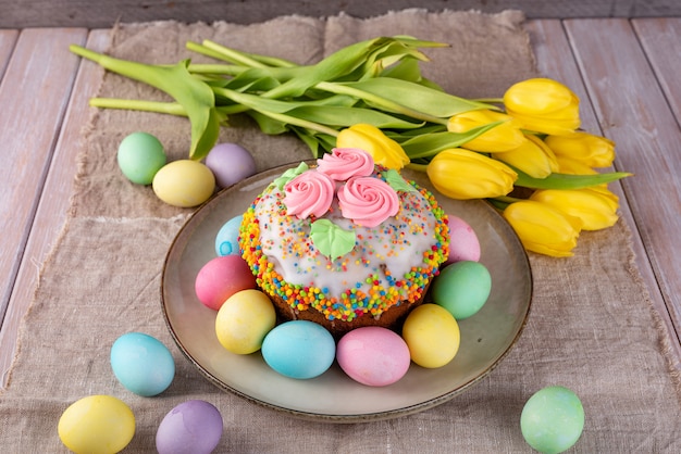 Torta de Pascua, huevos pintados con los tulipanes en un viejo fondo rústico de madera.