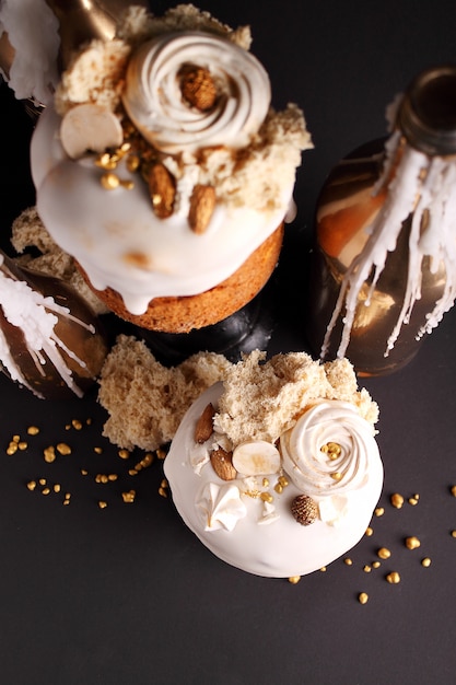 La torta de Pascua con pasas y frutas confitadas en esmalte blanco está decorada con nueces, galletas moleculares y merengue.