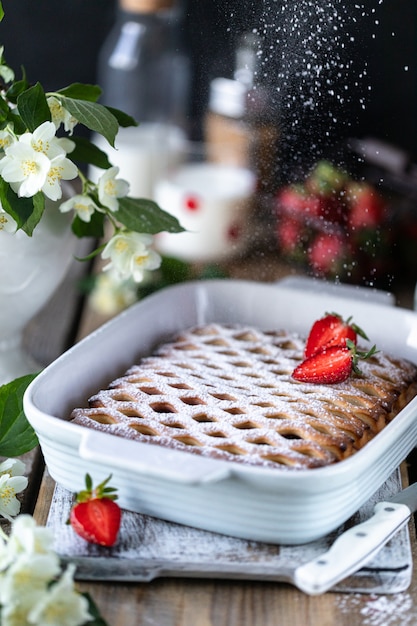 Torta saborosa de baga com morangos na mesa de madeira.